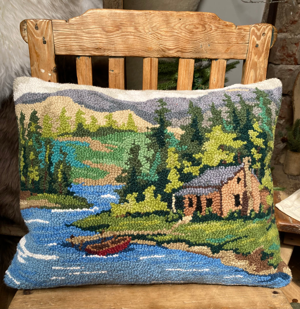 Hooked wool cushion featuring a lake and boathouse
